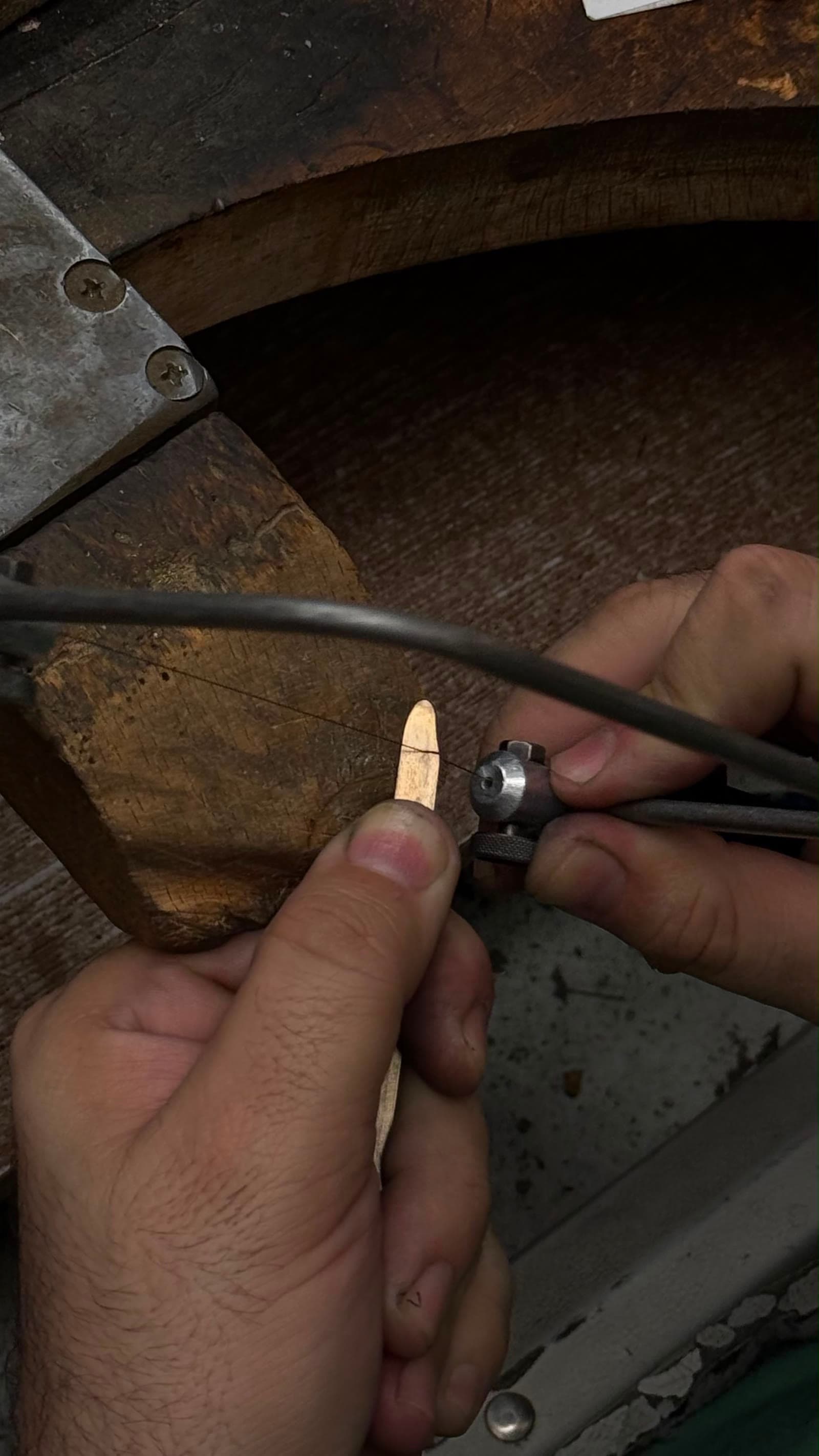 Bijutier modelând manual o piesă din metal la bancul de lucru